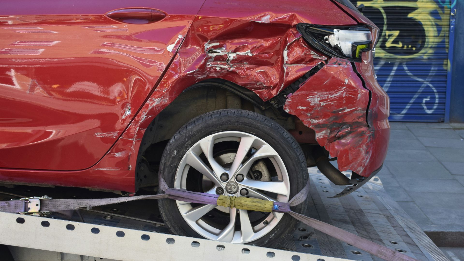 a red car is on a flatbed tow truck