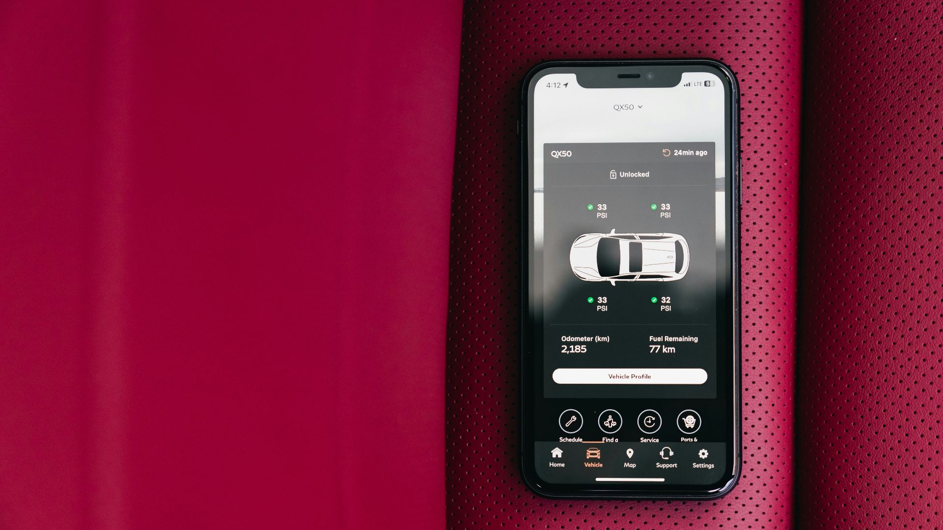 Smartphone displaying car control app on red seat