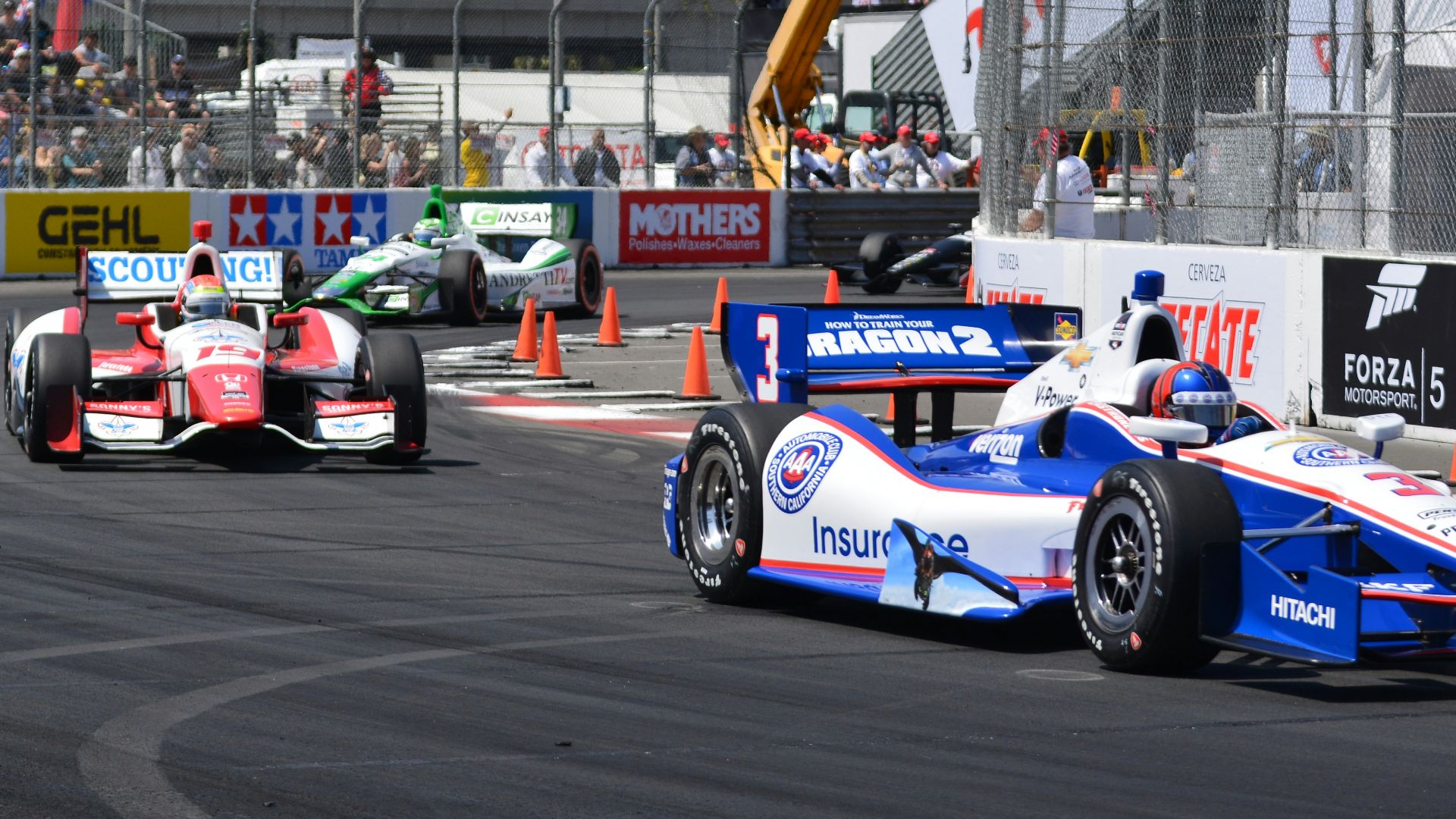 a group of racing cars driving down a race track