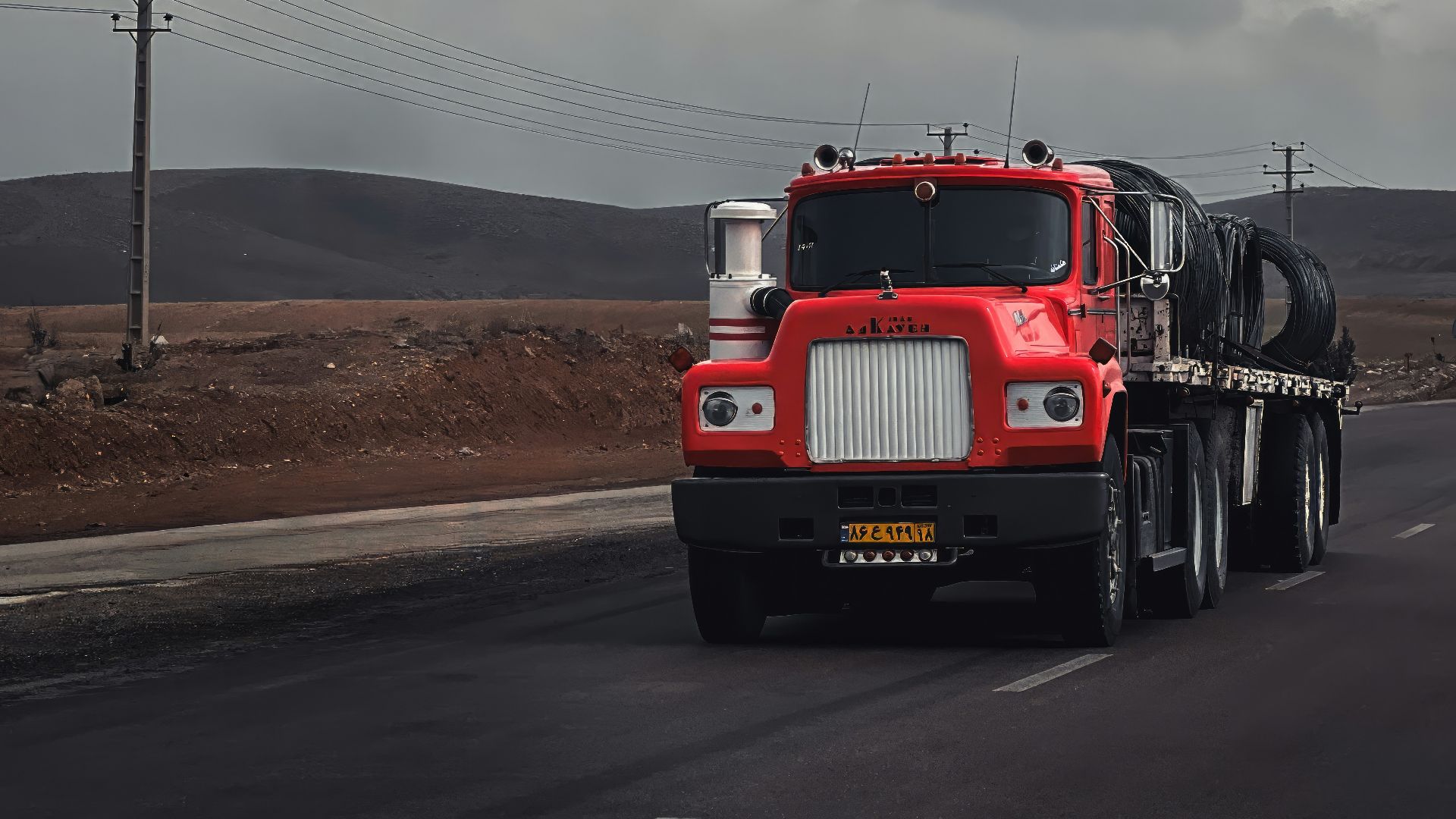 a red semi truck driving down a road