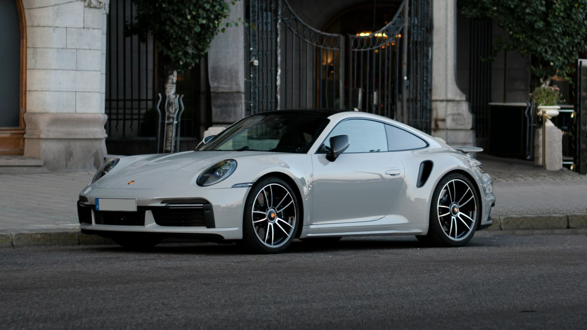 a white sports car parked on the side of a street